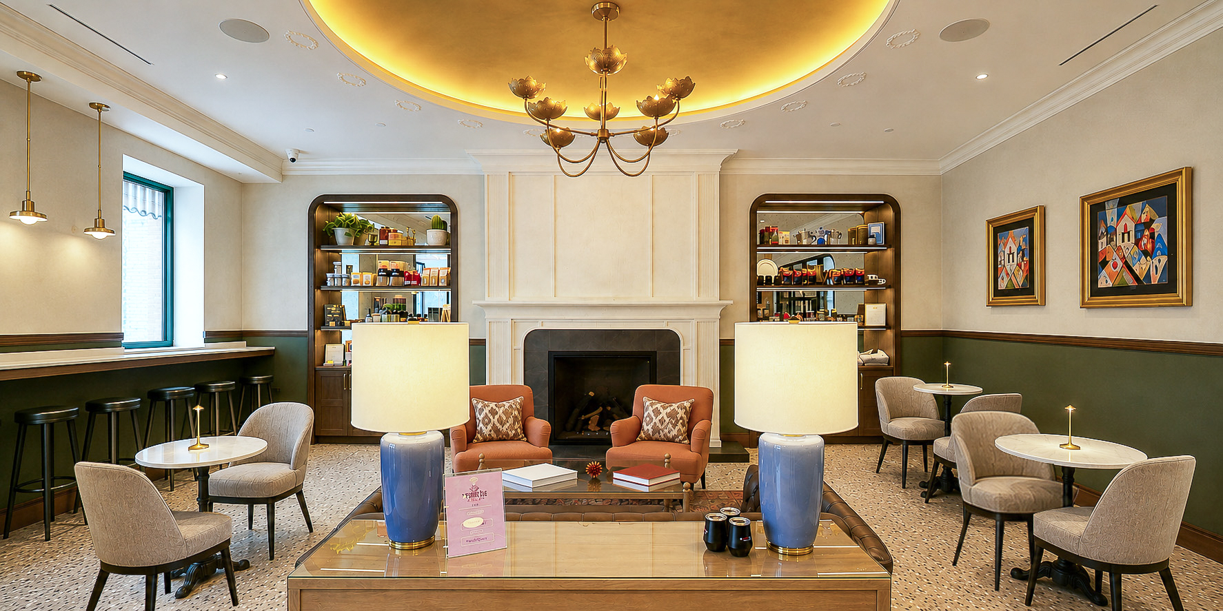 The Purple Pig market lounge with a central fireplace, terracotta armchairs, and brass lotus chandelier
