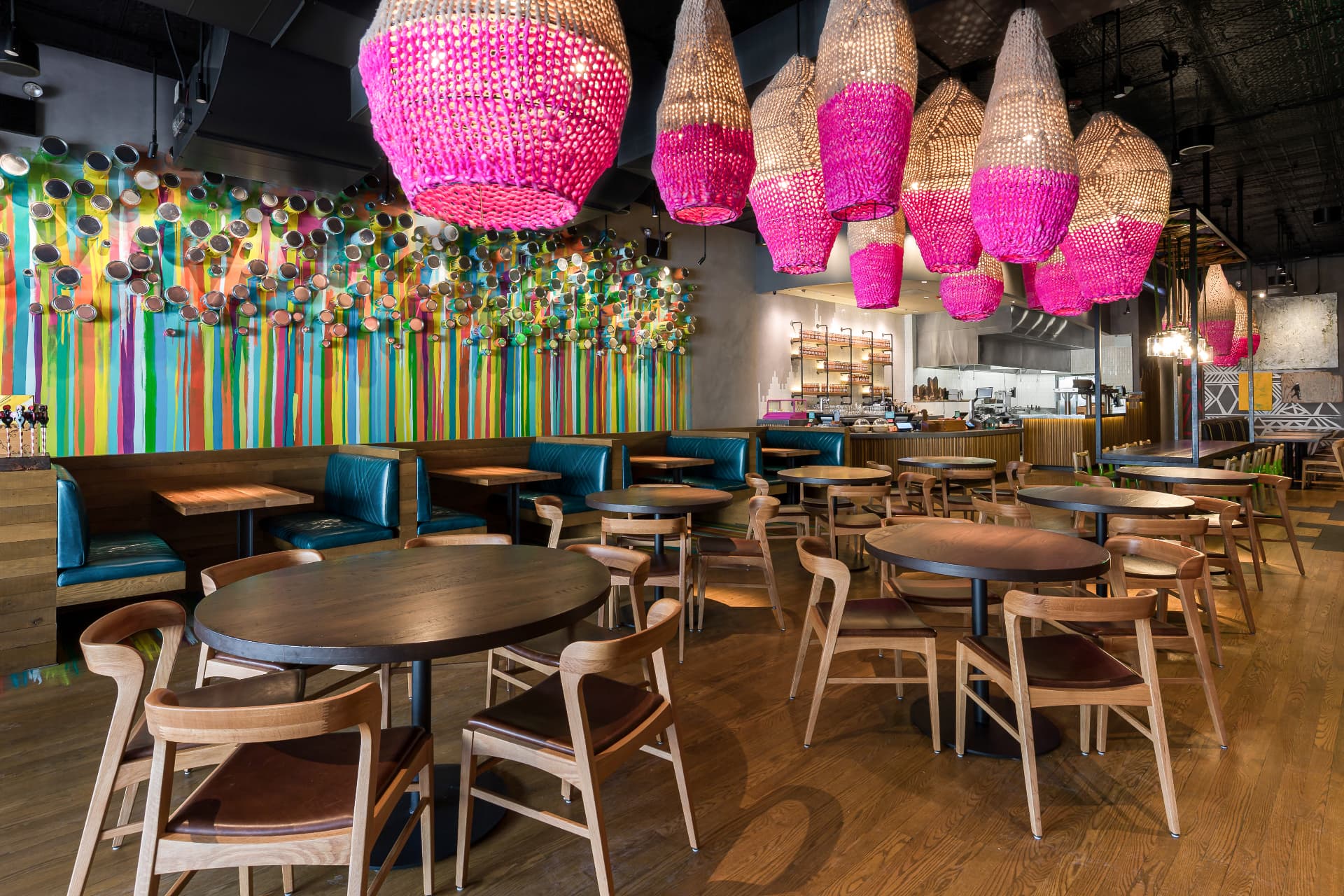 Nando's dining room with woven pendant lights and a colorful painted mural wall