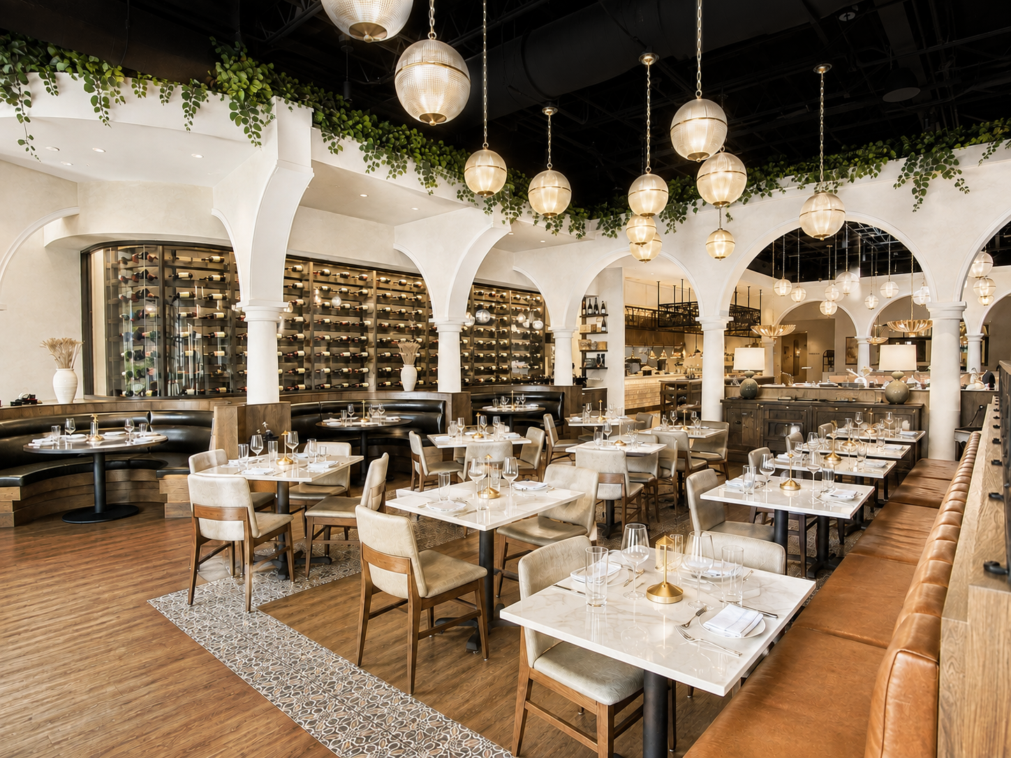 The Purple Pig dining room with white plaster arches, globe pendant lighting, and patterned tile flooring
