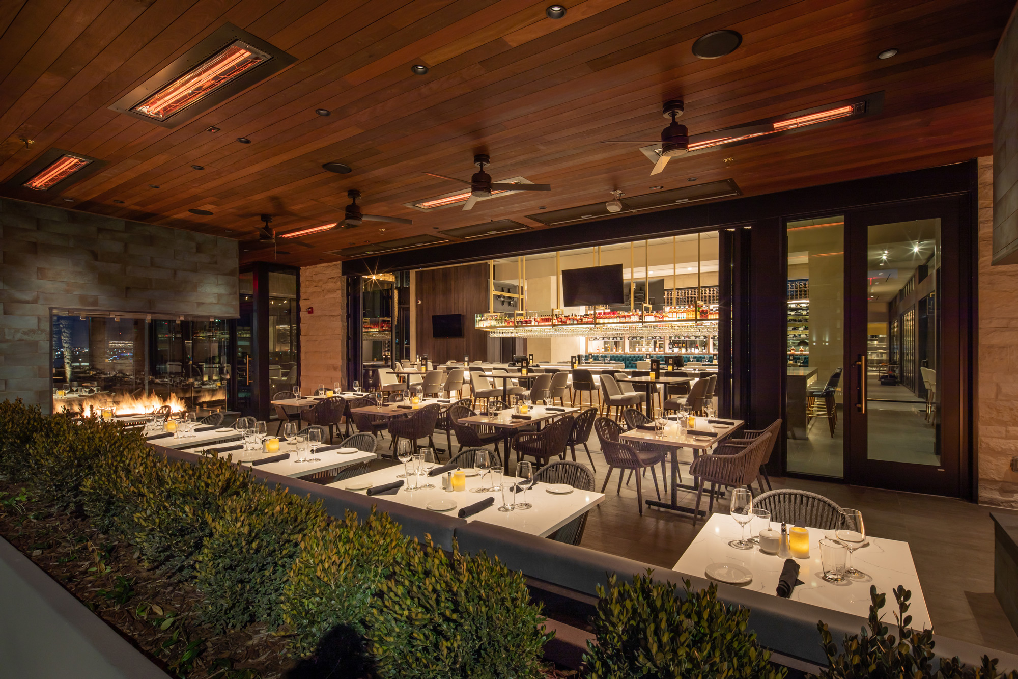Perry's Steakhouse outdoor patio at Cool Springs with covered dining, warm lighting, and a fire feature